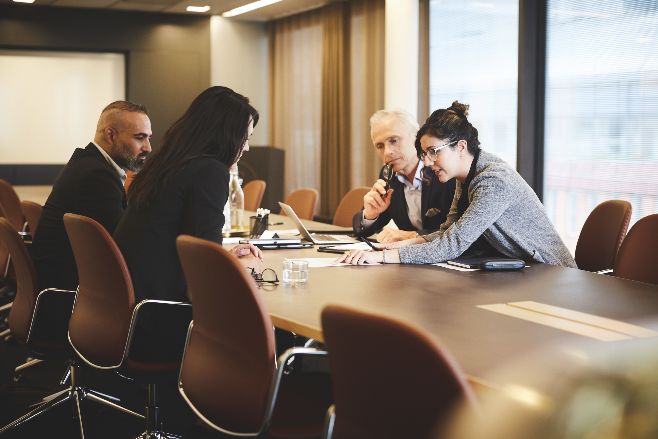 Group of business people sitting in an office having a meeting.