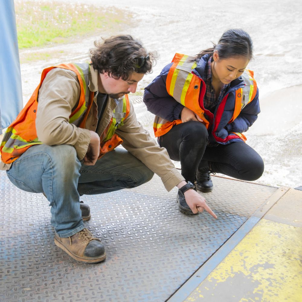 Construction workers looking at paint on the floor.