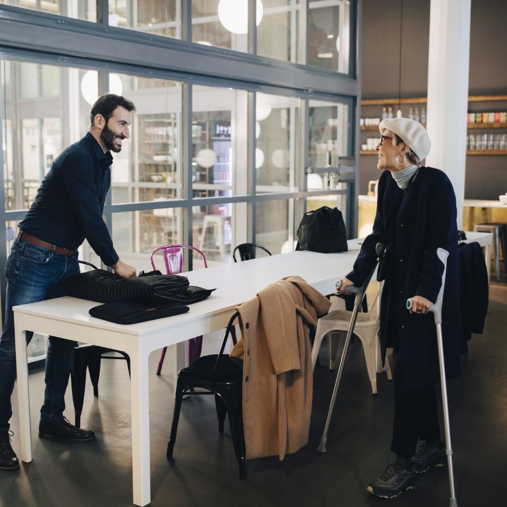 Woman in crutches talking to an employee.