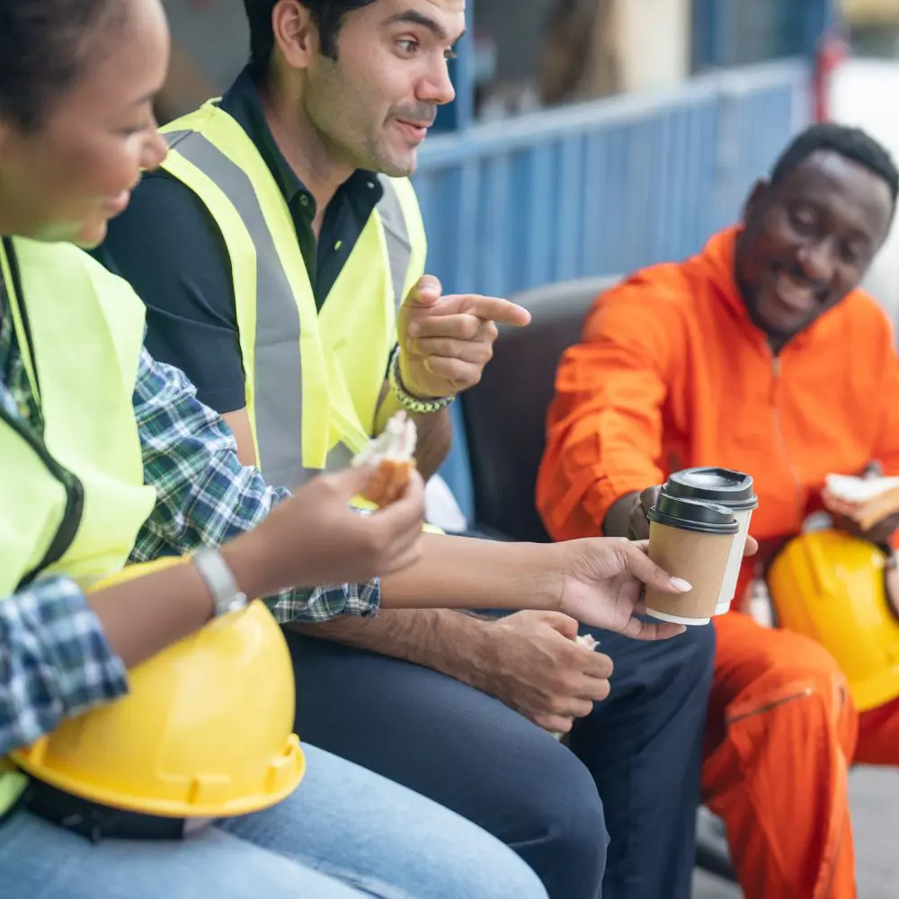 Construction workers having lunch, wearing yellow vests