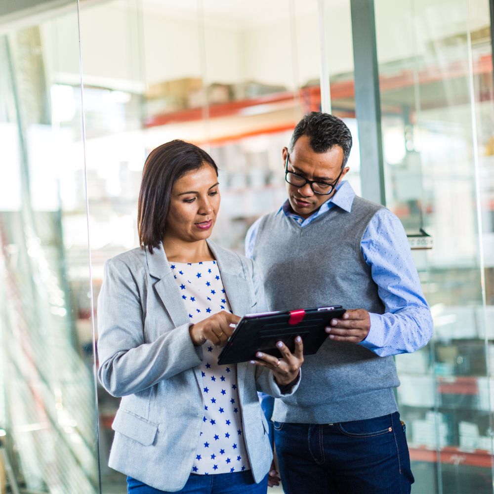 Two co-workers interacting with a tablet computer.