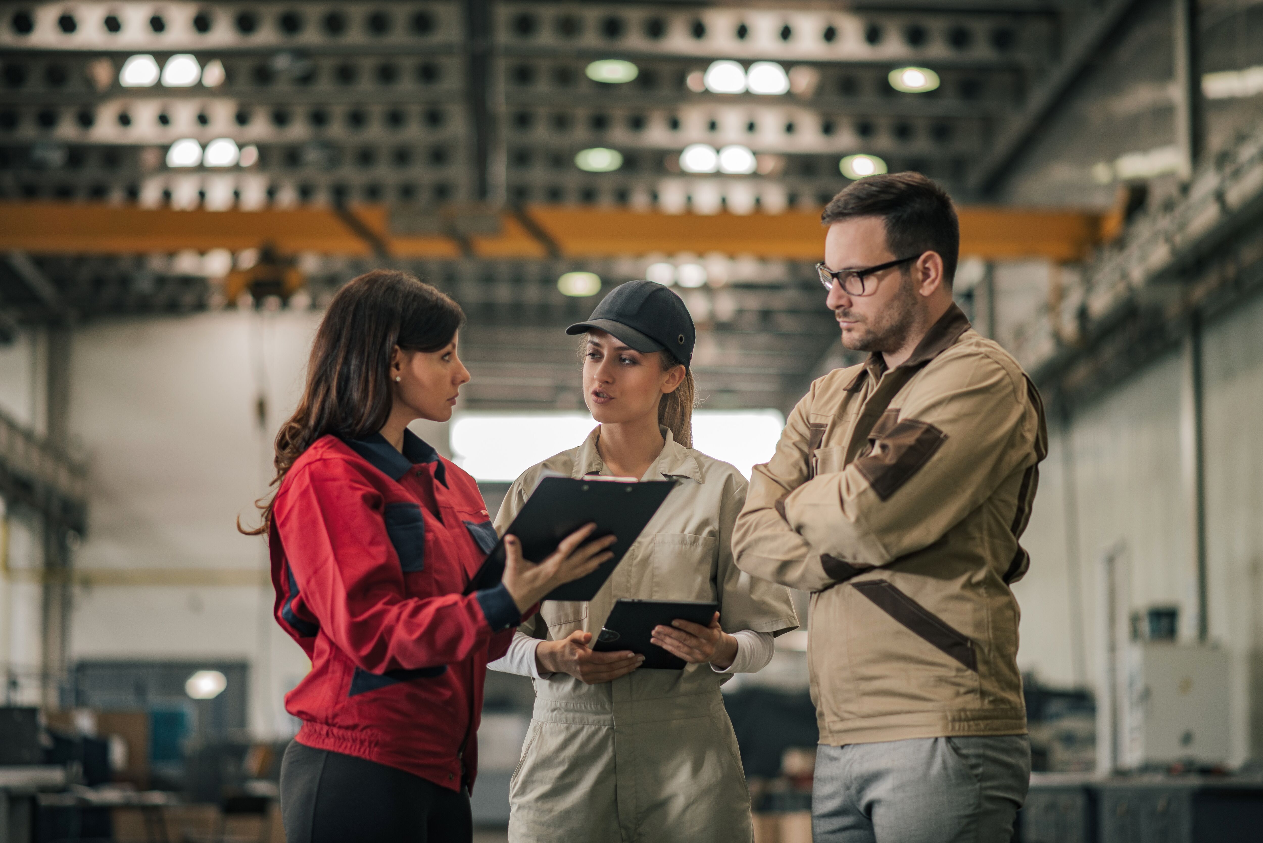 Three workers having a conversation in a factory