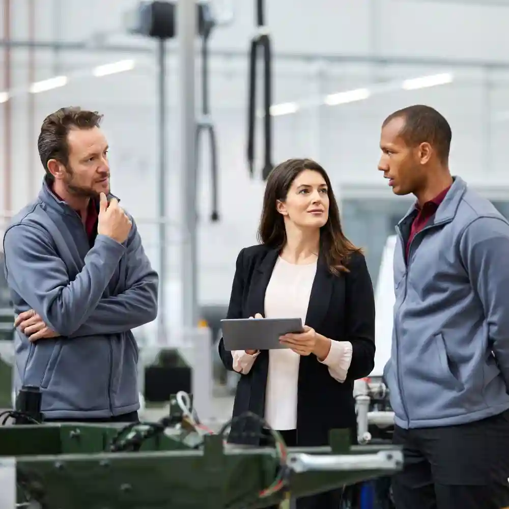 Three consultants talking, with one holding a tablet.