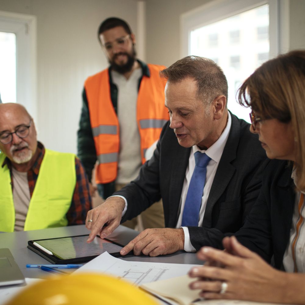 Consultants reviewing construction plans on a tablet.