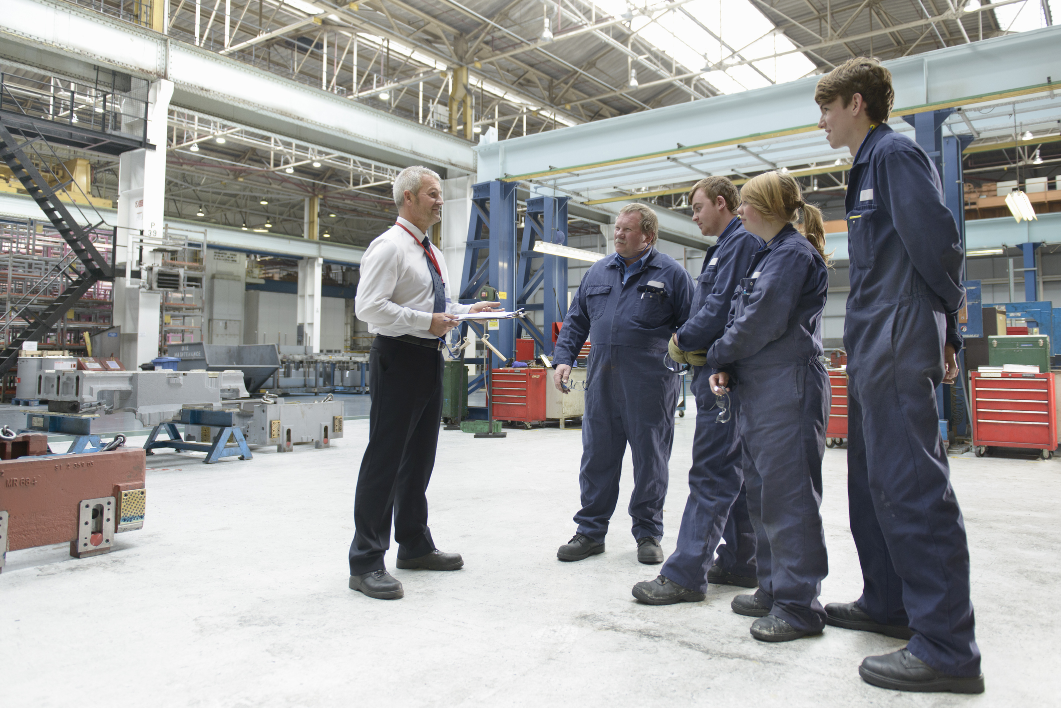 Safety instructor speaking to factory workers.