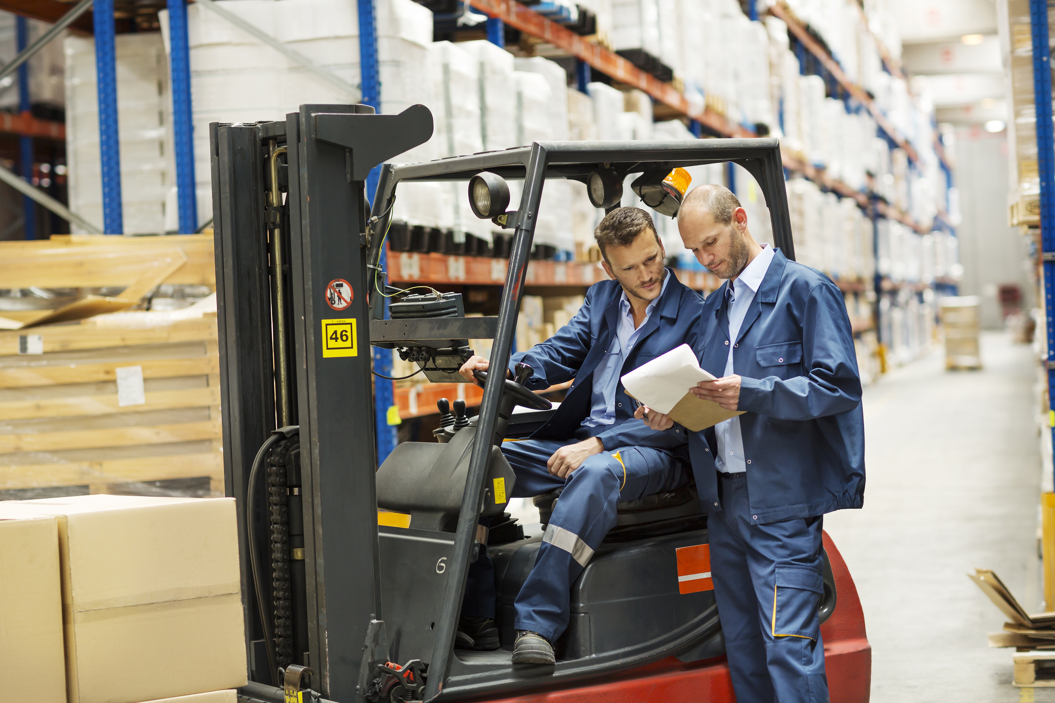 Two factory workers looking at a clipboard.